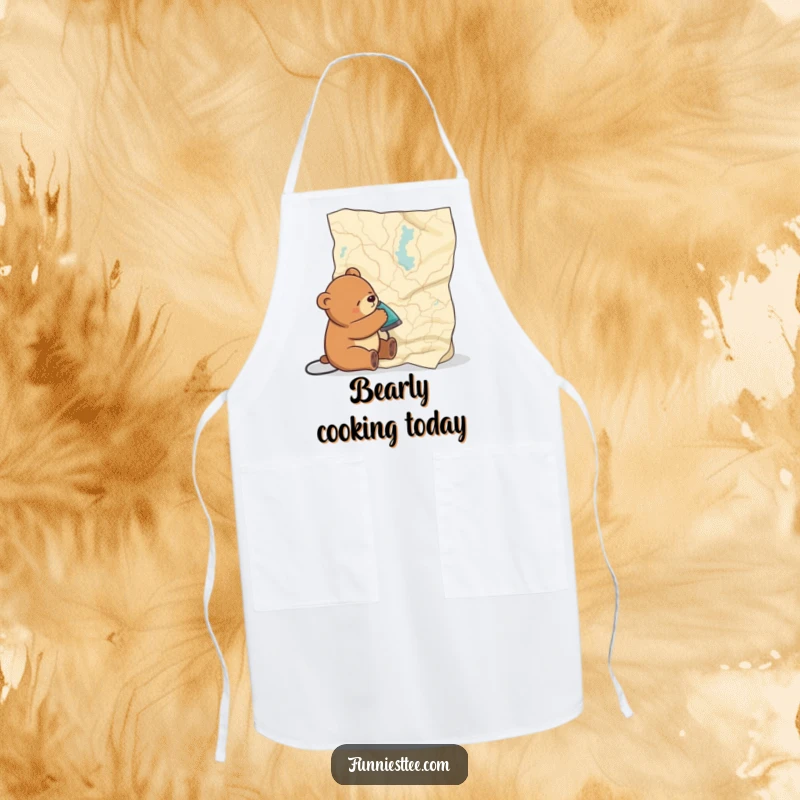 Funny apron depicting a sleepy bear comically attempting to flatten a giant map with an iron, designed for a humorous cooking experience.