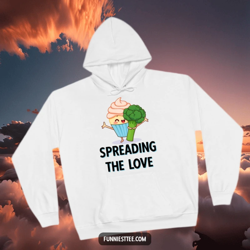 Funny hoodie featuring a happy cupcake with frosting arms outstretched, trying to hug a grumpy broccoli, a sweet and humorous garment.