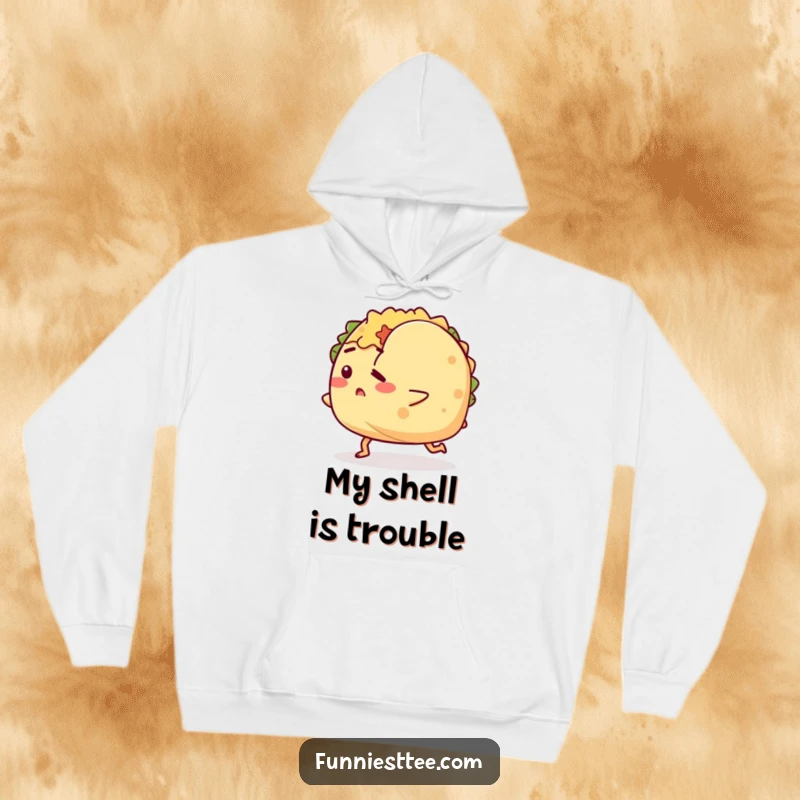 Funny hoodie with a determined taco character tripping over its shell, offering a cozy and humorous way to embrace imperfections.