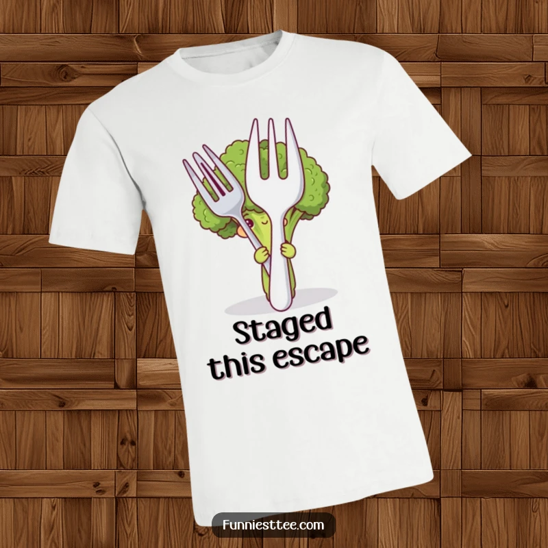 Funny t-shirt featuring a shy broccoli hiding behind a comically large fork and spoon, expressing a cute and humorous personality.