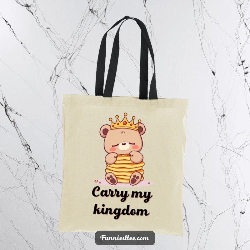 Funny sleepy bear tote bag showing a crowned bear character struggling to balance a large stack of pancakes, perfect for carrying essentials.